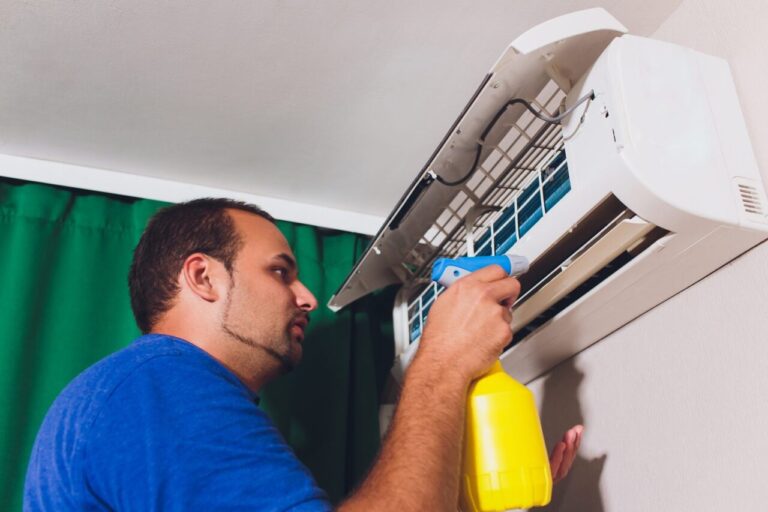 Technicien nettoyant l’unité intérieure d’une climatisation split au printemps.