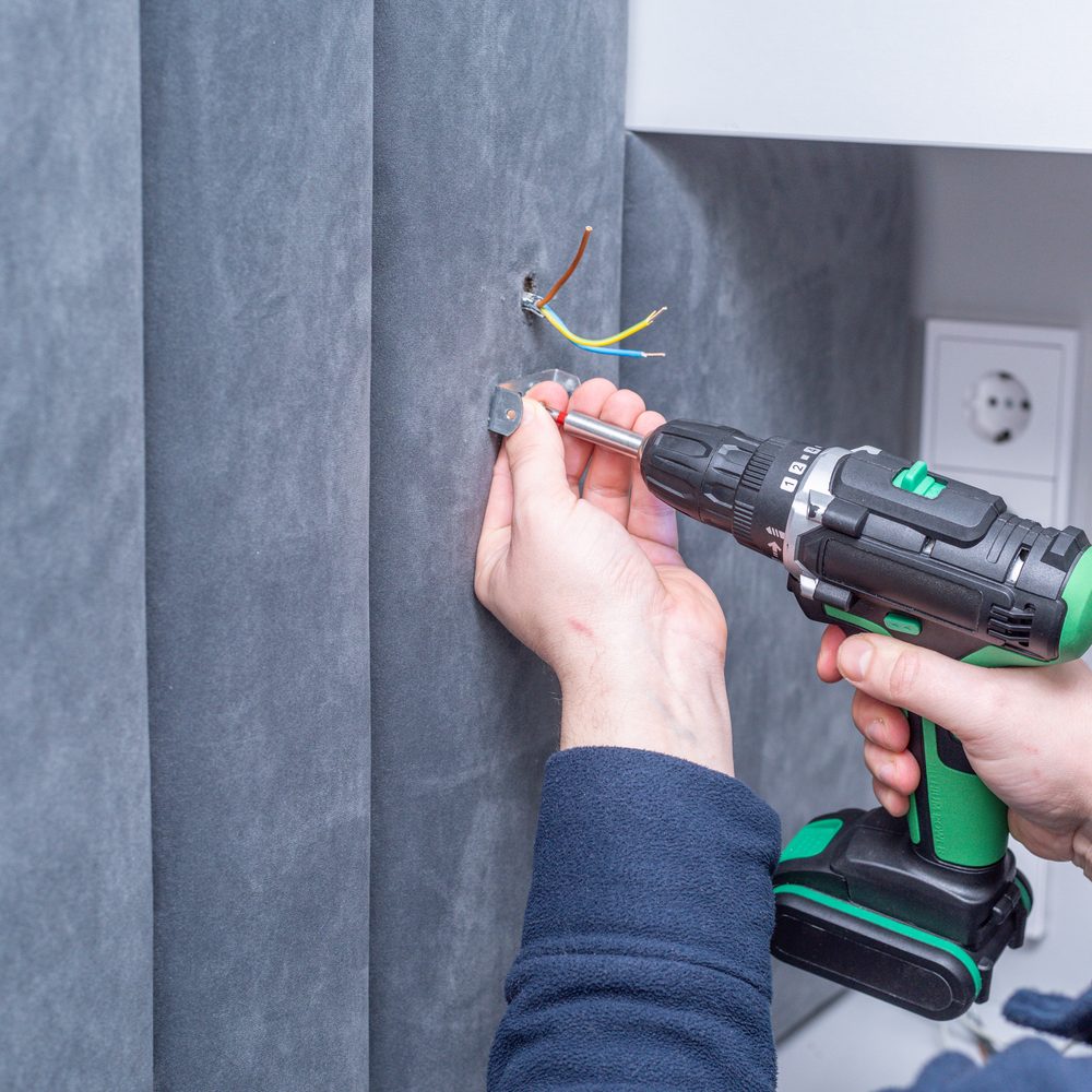 Mise en place de l’isolant autour de prises et d’un interrupteur sur un mur intérieur.